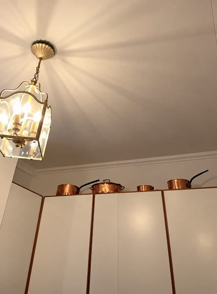 Cuisine après rénovation avec plafond clair et éclairage