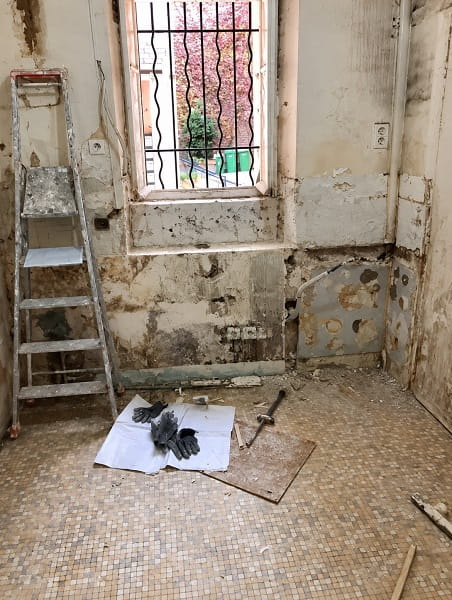 Studio avant rénovation avec anciens revêtements déposés et gravats